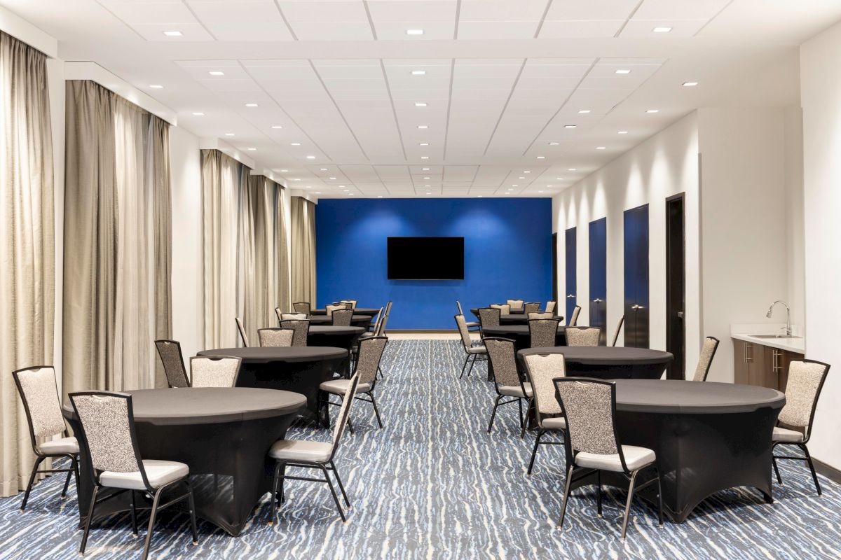 Conference room arranged with round tables and chairs.