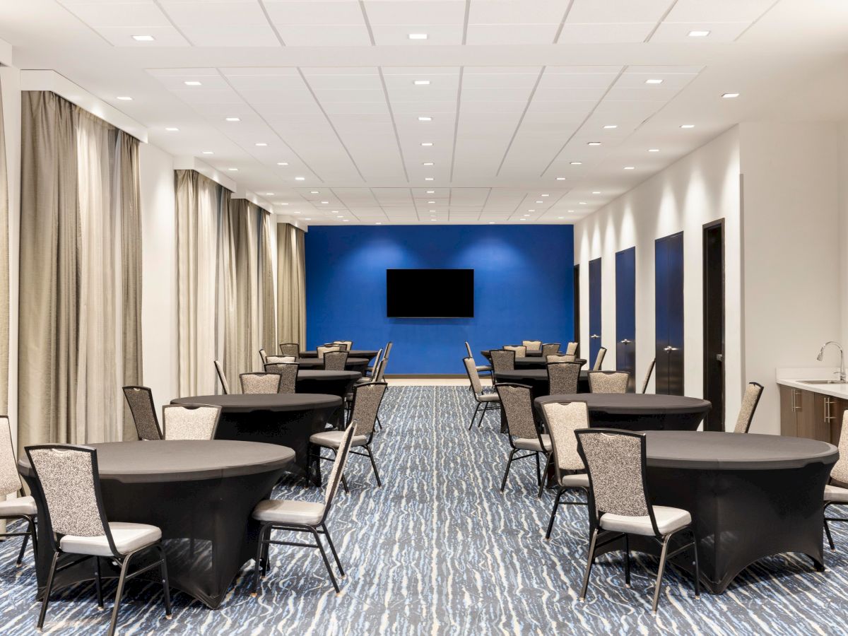 Conference room arranged with round tables and chairs.