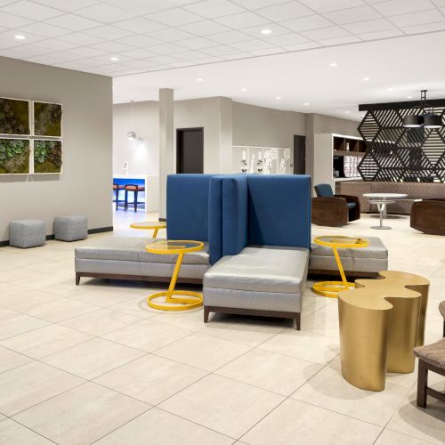 Lobby seating with blue armchairs and geometric room dividers.