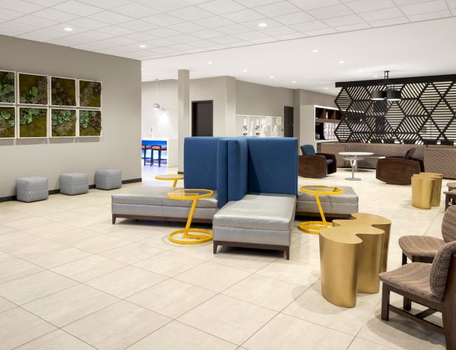 Lobby seating with blue armchairs and geometric room dividers.